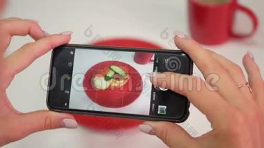 <strong>餐馆</strong>里的一个女人用手机摄像头拍下食物的照片。 在一家<strong>餐馆</strong>里给食物拍照